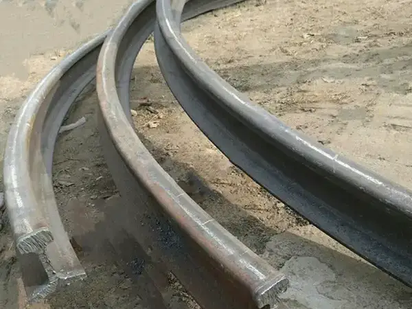 Bent steel rail for curved track