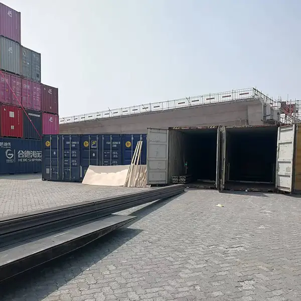 Forklift loading steel rails into container