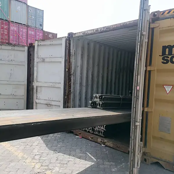 Forklift placing steel sections into container