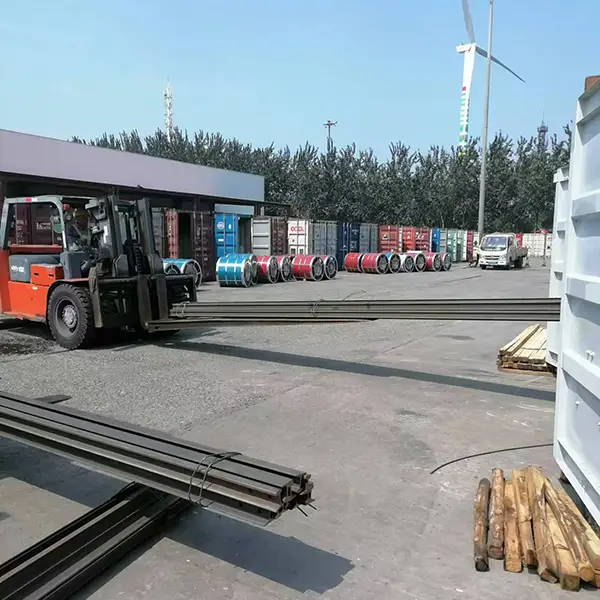 Forklift transporting steel bundles to container