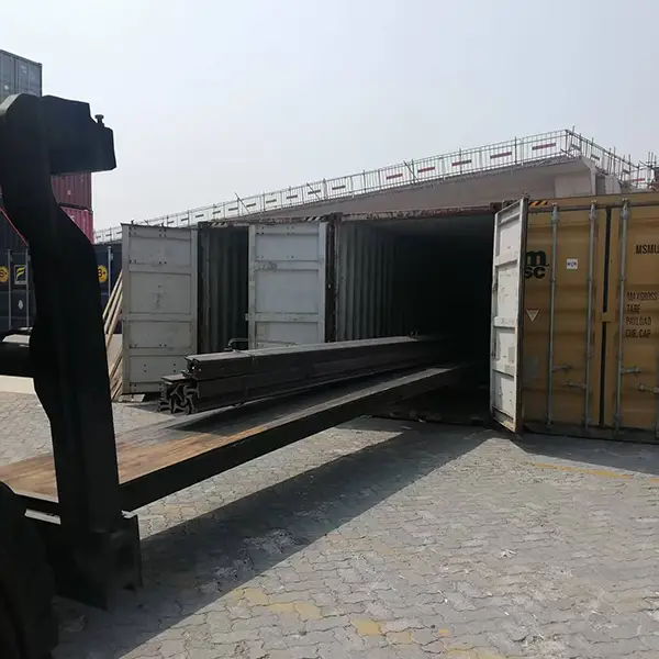 Forklift transporting steel bundles to container