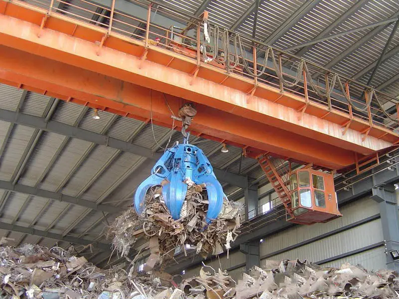 Blue Crane Grab Handling Scrap Metal in Workshop