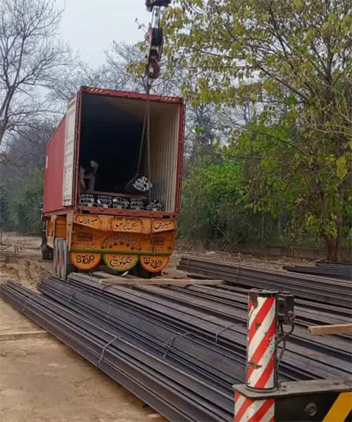 Local crew unloading rail bundles at project site
