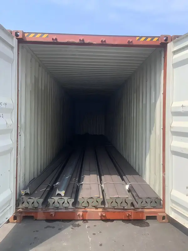 Steel rails secured with steel bands inside containers before shipment to Saudi Arabia